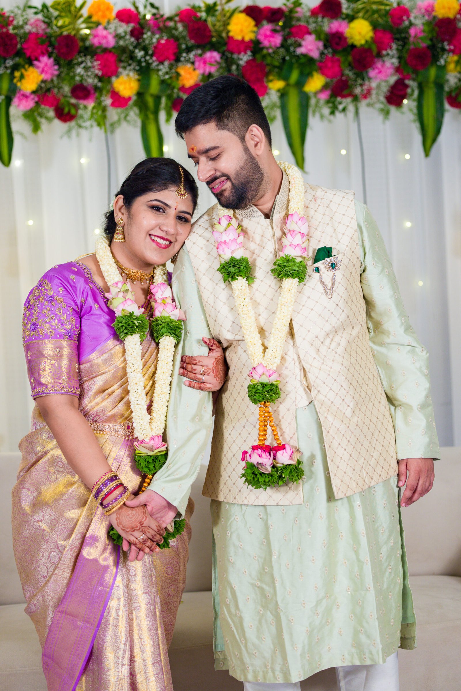 Engaged couple wearing flower garlands